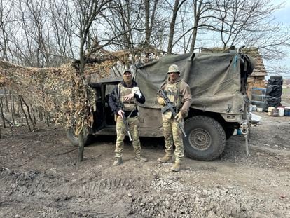 Los soldados ucranios Kotya y Sova con uno de los perros que vive con ellos en el frente de Robotine.
